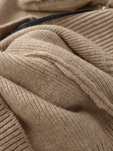 Close-up of premium camel knit texture with detailed faux fur effect on a stylish jacket