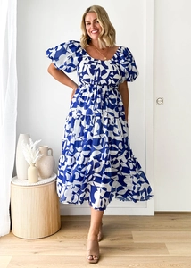 Detail of blue and white floral printed midi dress with puff sleeves and layered skirt