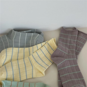 Detailed close-up of ribbed cotton socks in grey, yellow, brown, and green