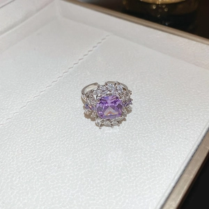 Detailed view of luxury silver open ring with large purple zircon and floral cluster design