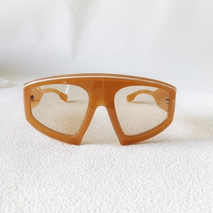 Detailed top view of trendy oversized shield sunglasses with warm orange transparent frames