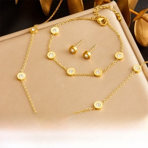 Detailed view of gold stainless steel jewelry set with Roman numeral zircon pendants