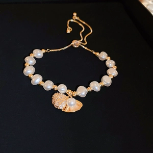 Detailed close-up of zircon shell pearl bracelet with gold finish and adjustable chain