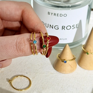 Close-up of minimalist 18K gold plated stainless steel rings with colorful birthstones