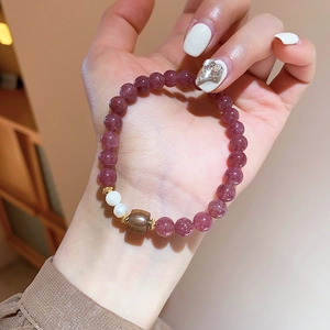 Nahaufnahme von Erdbeerquarz-Perlen und Süßwasserperlen am eleganten Vintage-Armband