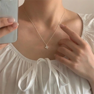 Minimalist 925 sterling silver cross necklace with sparkling zircon on a female model