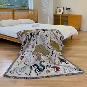 Detail of woven forest tapestry featuring mystical animals and fine fringe edges