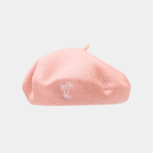 Close-up of pink wool beret featuring detailed white palm tree embroidery and soft texture