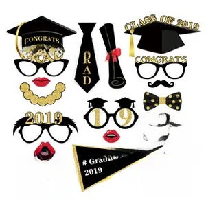 Close-up of black and gold graduation photo booth props including 2019 cap and tie