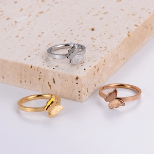 Detailed view of butterfly rings in gold, silver, and rose gold with matte textures