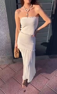 Détail de la texture plissée blanche du haut bandeau et de la jupe longue assortie au soleil