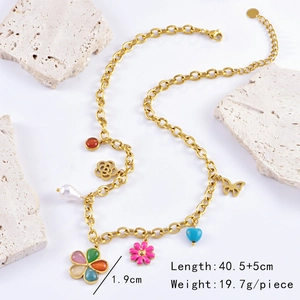 Detailed view of vintage gold necklace with enamel flower and colorful charms on stone