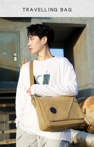 Detail of khaki canvas messenger bag with round leather patch and wide shoulder strap