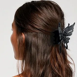 Large black butterfly hair claw clip with hollow design on dark hair back view