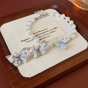 Détail de l'ensemble bracelet et boucles d'oreilles papillon en perles avec cristaux bleus