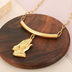 Détail d'un collier doré avec pendentif soleil sur un plateau en bois brun