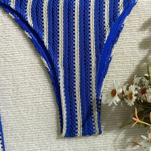 Gros plan détaillé du bas de bikini au crochet à rayures bleues et beige sur tapis