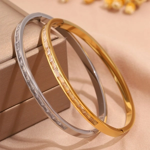 Detail of gold and silver titanium steel bangles with rectangular cubic zirconia inlay