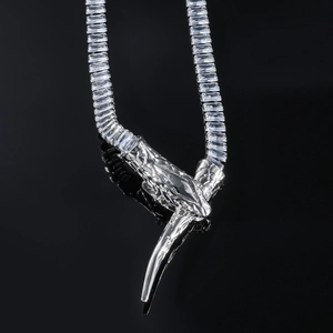 Silver snake head necklace with square cubic zirconia and fangs on black background