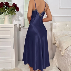 Nuisette longue en satin bleu marine avec dentelle au dos présentée dans une chambre douce