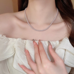 Close-up of the elegant single strand pearl necklace showing glossy round pearls