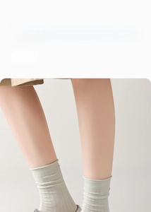 Close-up of light green mesh knit socks with ribbed cuffs and breathable eyelet texture