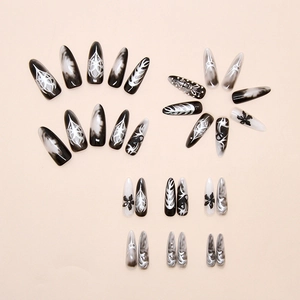 Detail of stiletto press-on nails with silver blooming flower and dark butterfly art