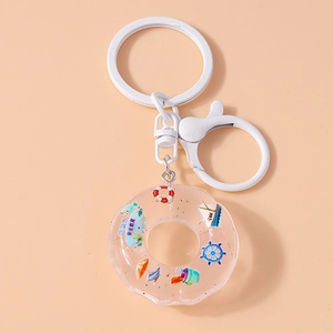 Detail of creative lifebuoy keychain with summer elements and safety text on warm background