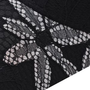 Close-up of black floral lace fabric on a baseball cap showing intricate hollow crochet texture