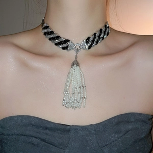 Close-up of pearl tassels on a rhinestone chain necklace worn by a fashion model