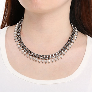 Close-up of 9mm Cuban chain and white pearl necklace set on a model's neck