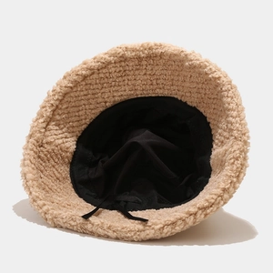 Thick beige plush bucket hat featuring black inner lining and adjustable drawstring cord