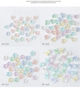 Close-up of heart, star and bow resin nail charms with iridescent polar glitter effects