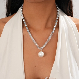 Close-up of elegant necklace with grey pearls, clear crystals and large white pearl pendant