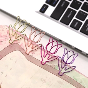 Close-up of tulip-shaped metal paperclips in gold and pink on a planner page