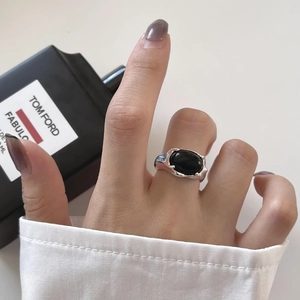 Close-up of a vintage silver ring with oval black onyx gemstone and wavy texture