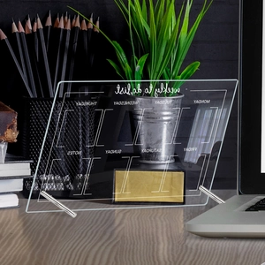 Macro detail of acrylic weekly planner with metal stands on a modern wooden desk