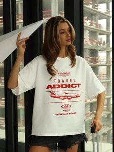 Dettaglio maglietta oversize in cotone bianco con stampa rossa a tema aereo travel