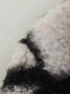 Macro shot of high-loft black and white checkered faux fur fabric texture for winter coats