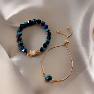 Elegant emerald-style bracelet set with deep blue beads and gold star moon pendants