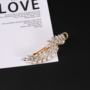 Elegant gold leaf-shaped hair clip with sparkling marquise rhinestones on a card