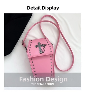 Gros plan détaillé du sac cercueil rose avec rivets et pendentif croix argentée rétro