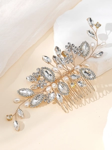 Detail of handmade gold bridal hair comb with shimmering crystals and white pearls