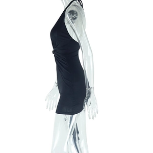 Side view of black backless halter mini dress showing slim fit and ruched knit fabric