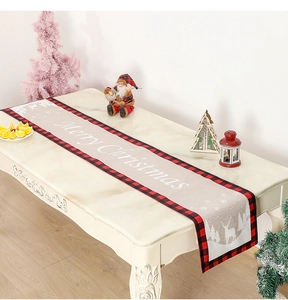 Détail du chemin de table de Noël avec bordure à carreaux rouges et motif renne