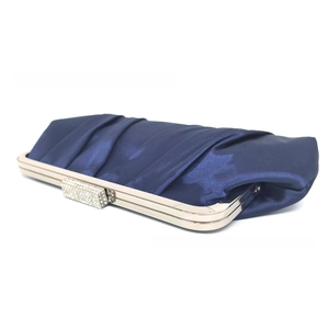 Detailed view of navy blue pleated satin clutch featuring a crystal encrusted silver clasp