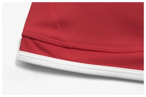 Macro detail of red sports bra fabric with white contrast piping and dual-needle stitching