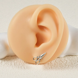 Silver scissor shaped stainless steel push-in labret stud earring shown on a model ear
