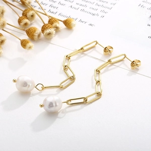 Vue détaillée de boucles d'oreilles vintage en perles dorées sur fond de papier décoratif