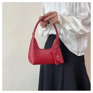 Detailed close-up of a red woven texture shoulder bag with matching coin purse accessory
